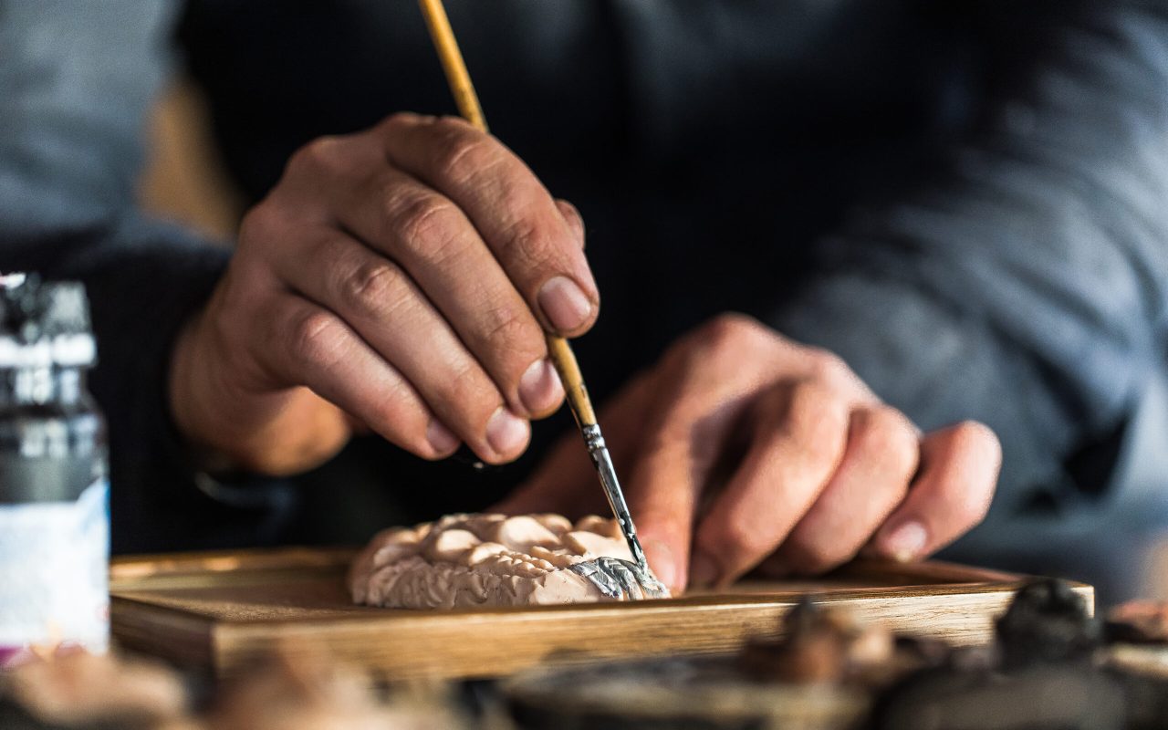 Master painting a gesso sculpture. High quality photo